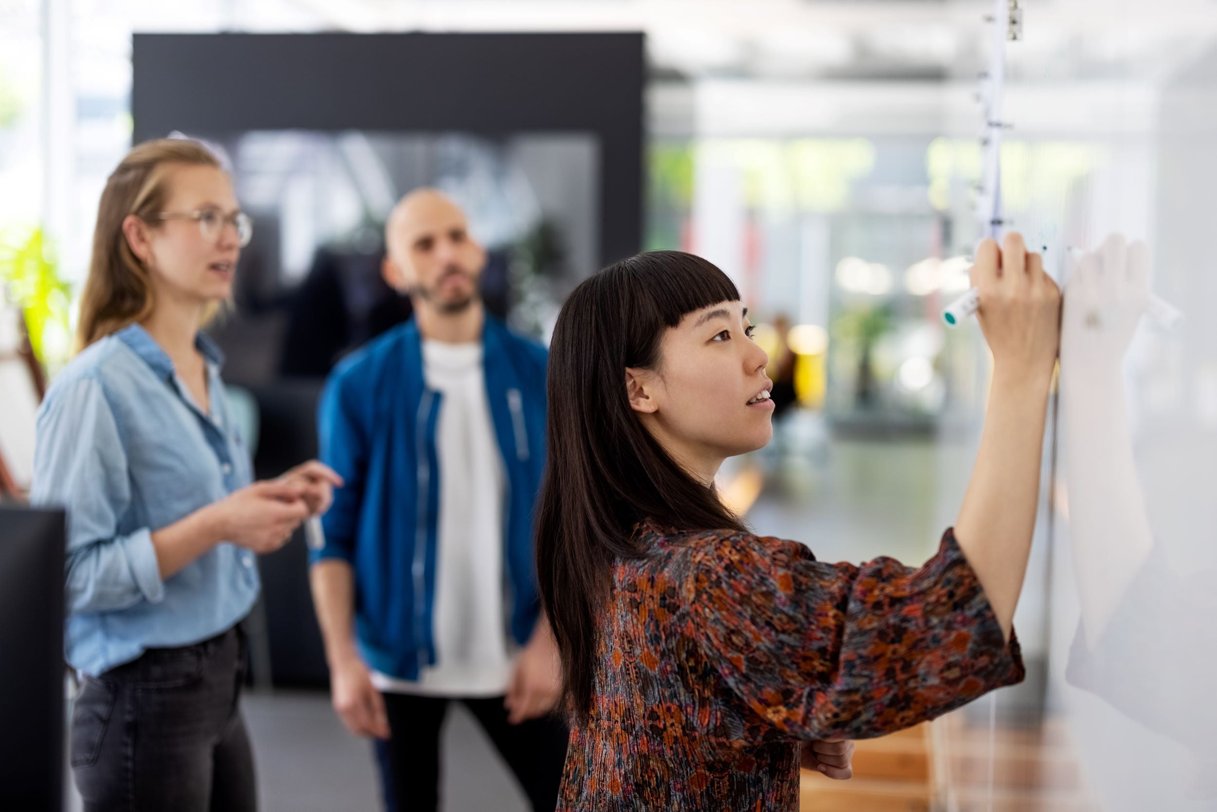 three coworkers whiteboarding ideas